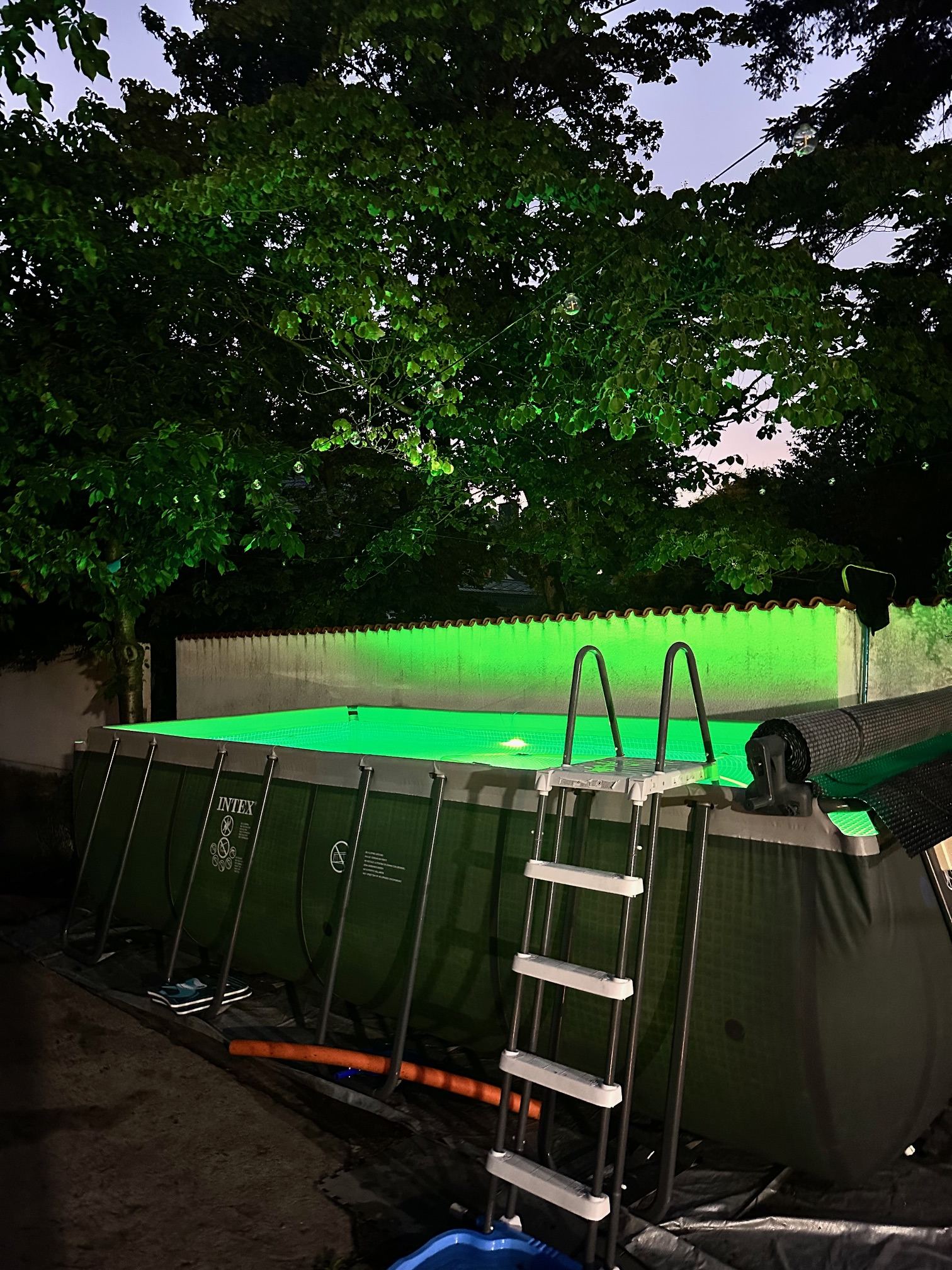 Beleuchteter Pool bei Nacht in Grün